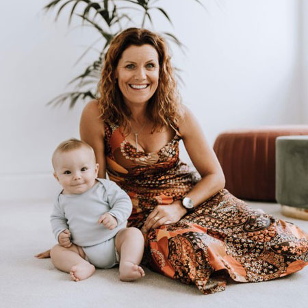 Woman sitting on the floor next to a baby